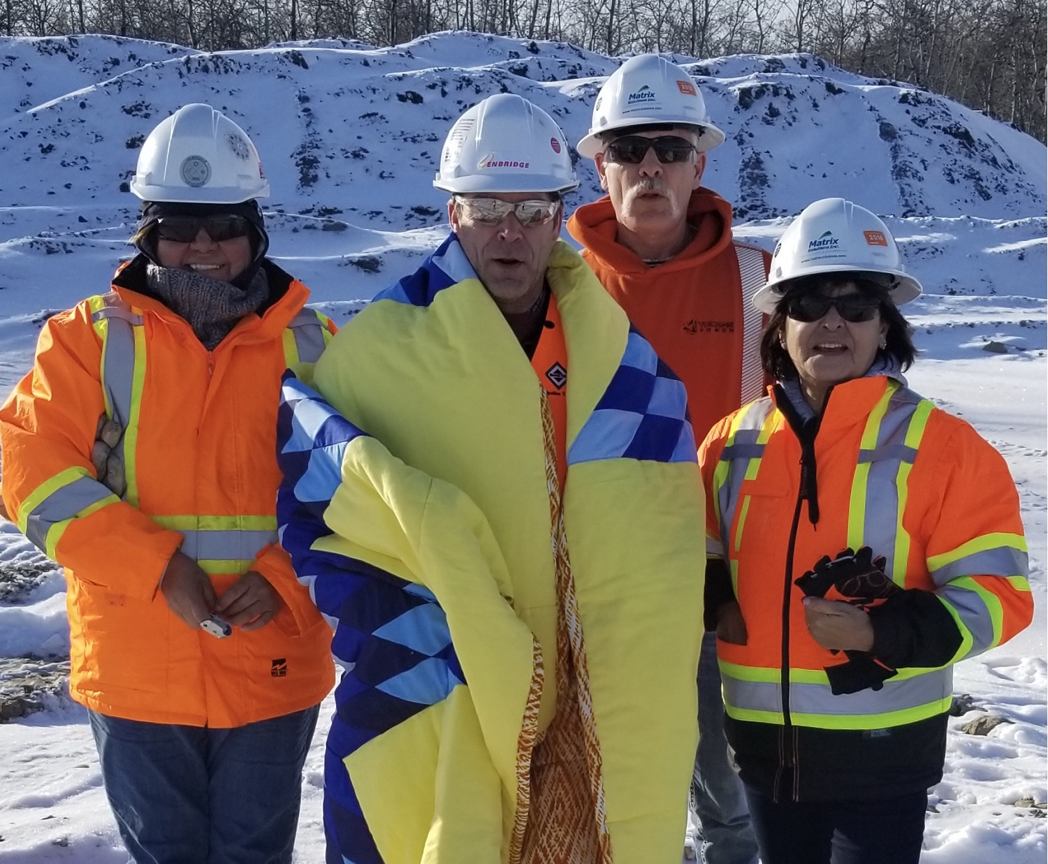 Four construction workers in winter one wearing a star blanket